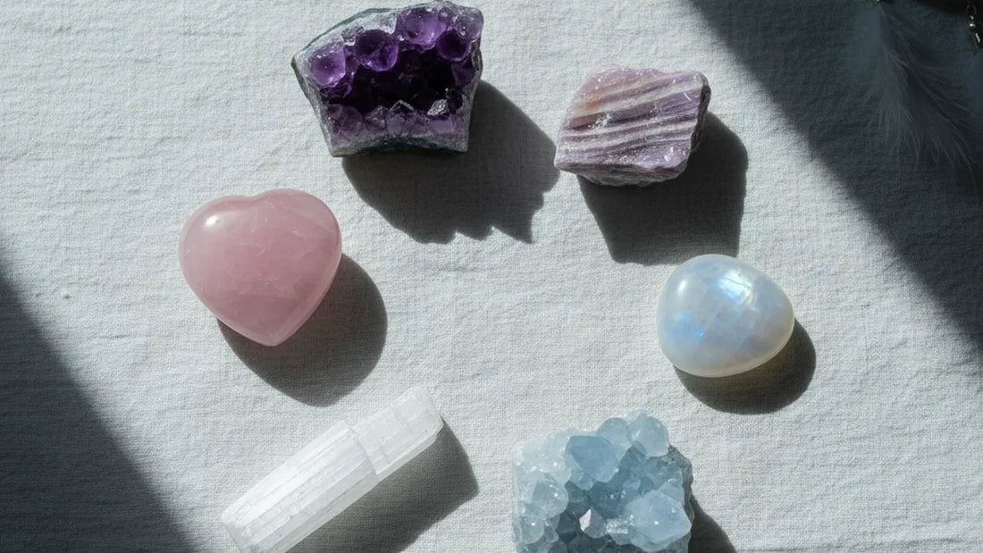 Las 6 mejores piedras naturales para dormir: amatista, cuarzo rosa, selenita, lepidolita, piedra luna y celestita sobre lino blanco con luz de luna