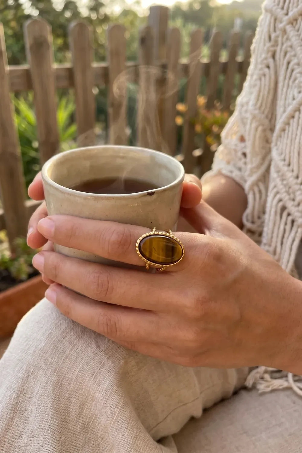 Mujer con anillo con ojo de tigre dorado sosteniendo una taza de café - Anna Piedra