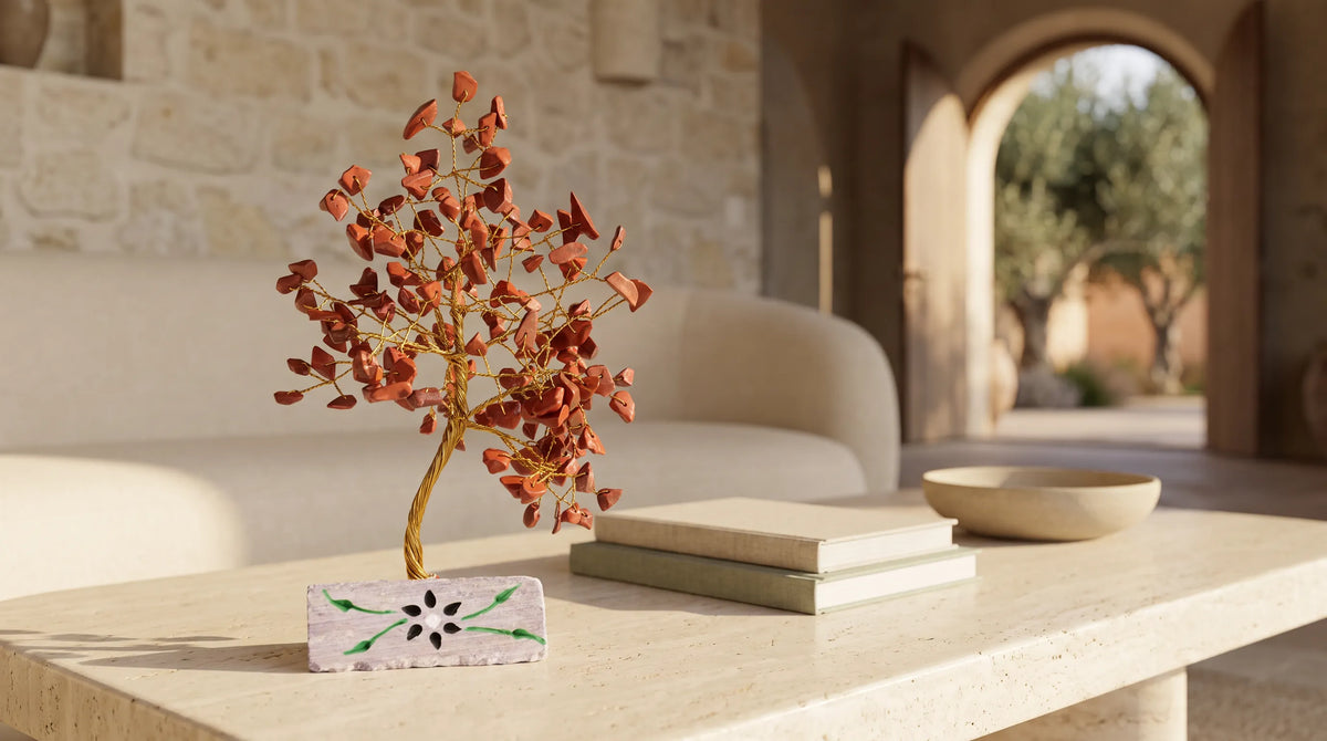 Árbol de la Vida de jaspe rojo colocado sobre una mesa de centro en un salón cálido de estilo mediterráneo.