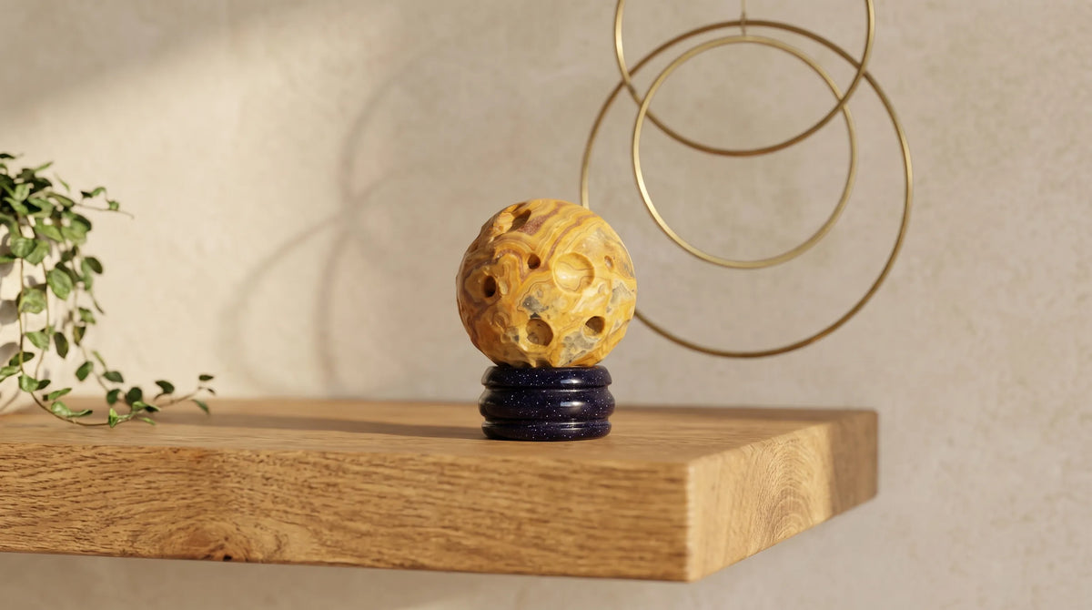 Planeta Mercurio de jaspe encaje loco sobre soporte azul colocado en una estantería de madera como objeto decorativo.
