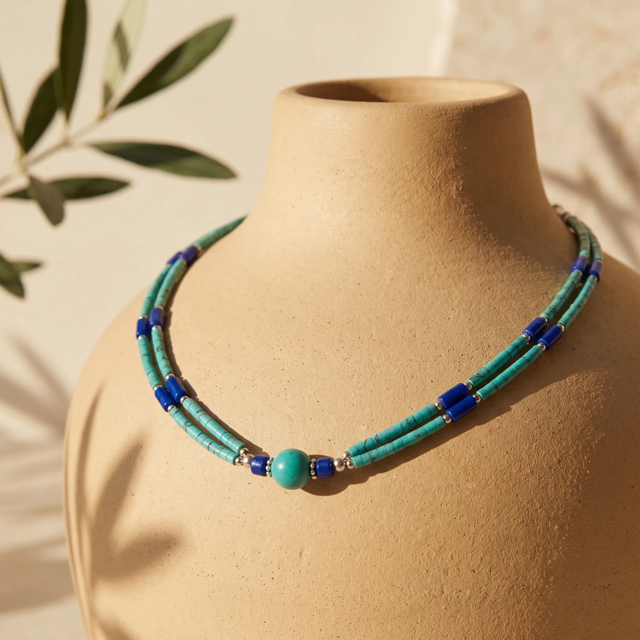 Collar de dos líneas con cuentas turquesa, detalles en lapislázuli y cuenta central de malaquita, sobre maniquí de cerámica - Anna Piedra