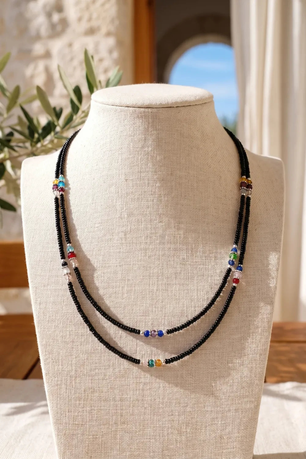 Collar nepalí de ónix de doble hilera presentado sobre un expositor de tela clara. anna piedra