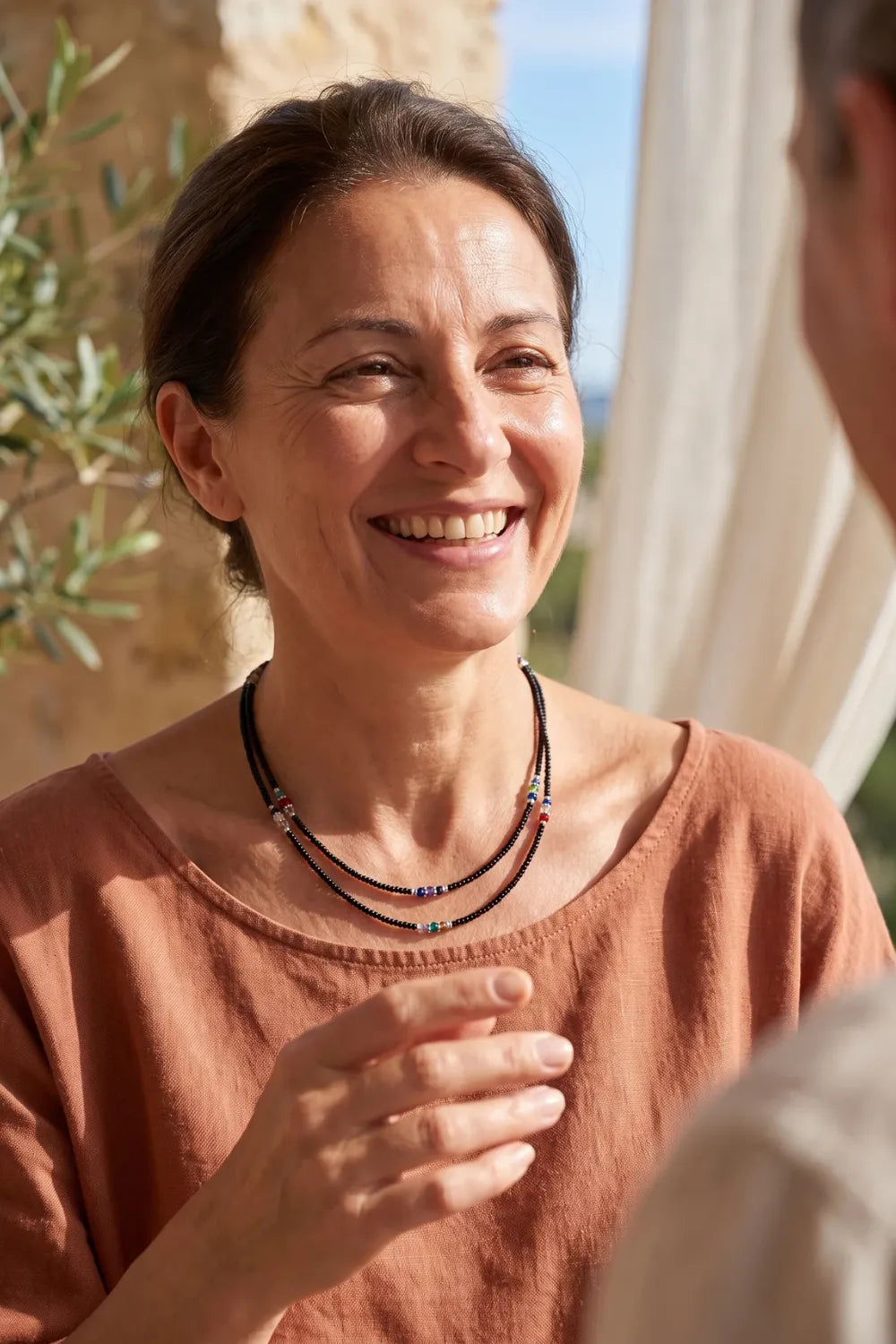 Mujer llevando un collar nepalí de ónix de doble hilera en un interior luminoso. anna piedra