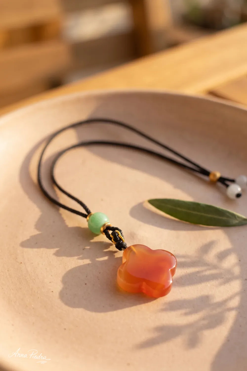 Detalle de collar con trébol de jade rojo y perla de jade verde