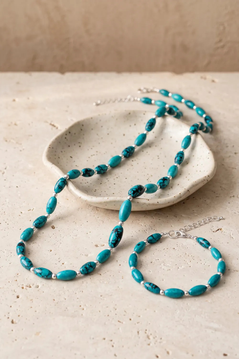 Conjunto de collar y pulsera de turquesa sobre una bandeja de cerámica