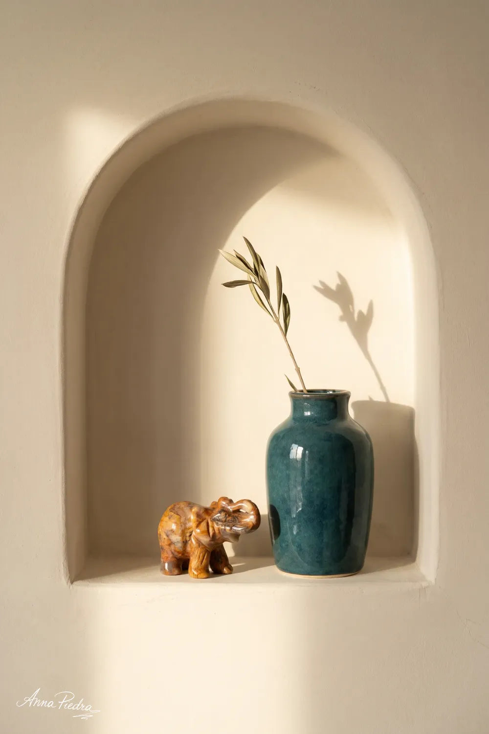 Elefante de la suerte de ágata encaje loco junto a un jarrón azul en una hornacina de pared - Anna Piedra