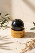 Esfera de turmalina negra sobre soporte de madera con decoración natural - Anna Piedra
