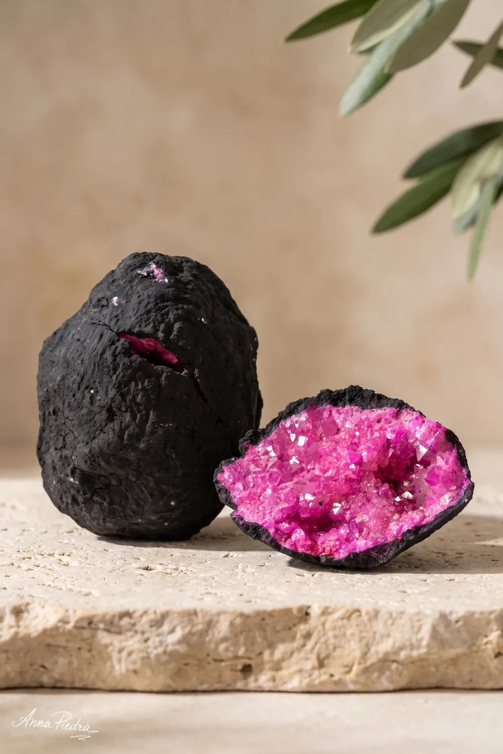 Geoda de calcita rosa mostrada cerrada y abierta para apreciar su exterior oscuro y sus cristales rosas interiores. anna piedra