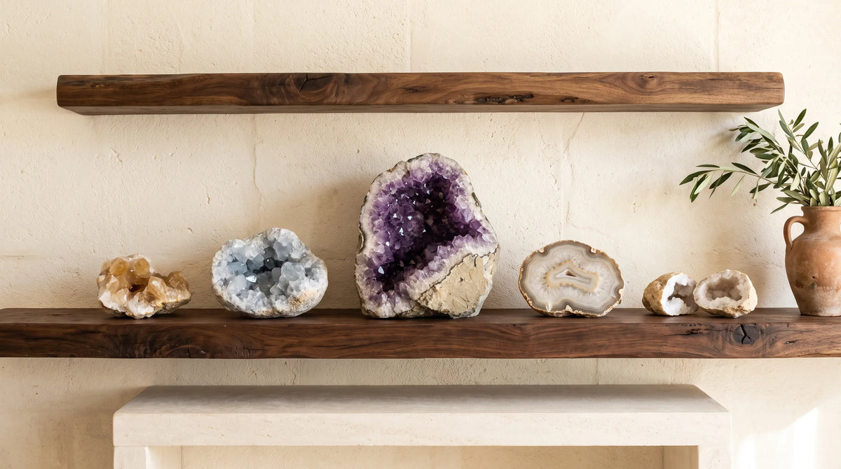 Colección de geodas naturales de amatista, cuarzo, calcita y ágata sobre una estantería de madera