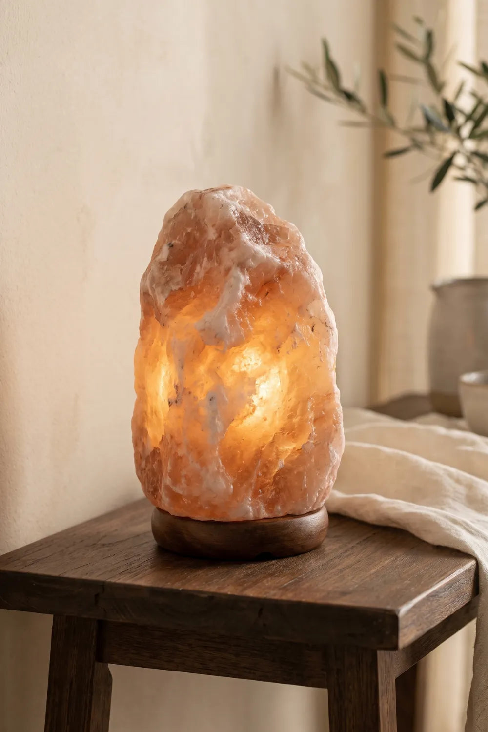 Lámpara de sal natural del Himalaya encendida sobre una mesa de madera