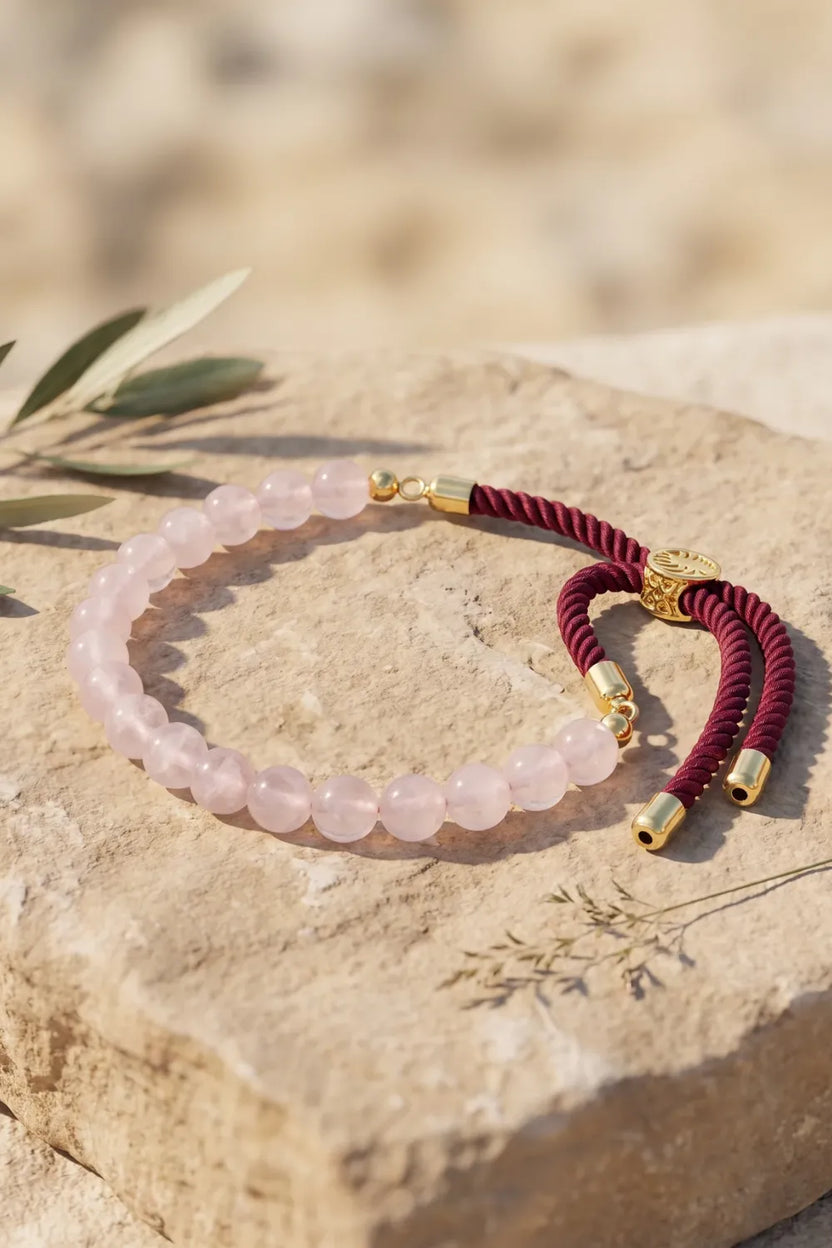 Pulsera de cuarzo rosa natural con cordón burdeos y detalles dorados - Anna Piedra