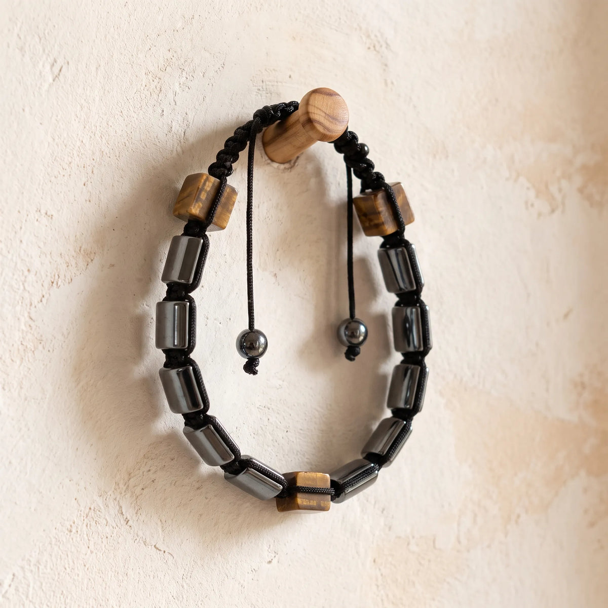 Pulsera shamballa ajustable de hematita y ojo de tigre con nudo de macramé y cierre de cordón negro.