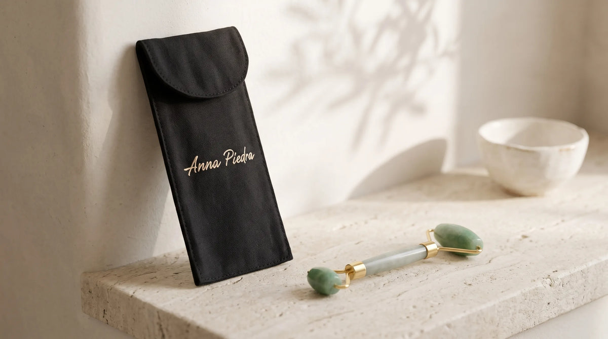 Rodillo de jade con funda negra de Anna Piedra sobre una repisa de piedra en un ambiente sereno.