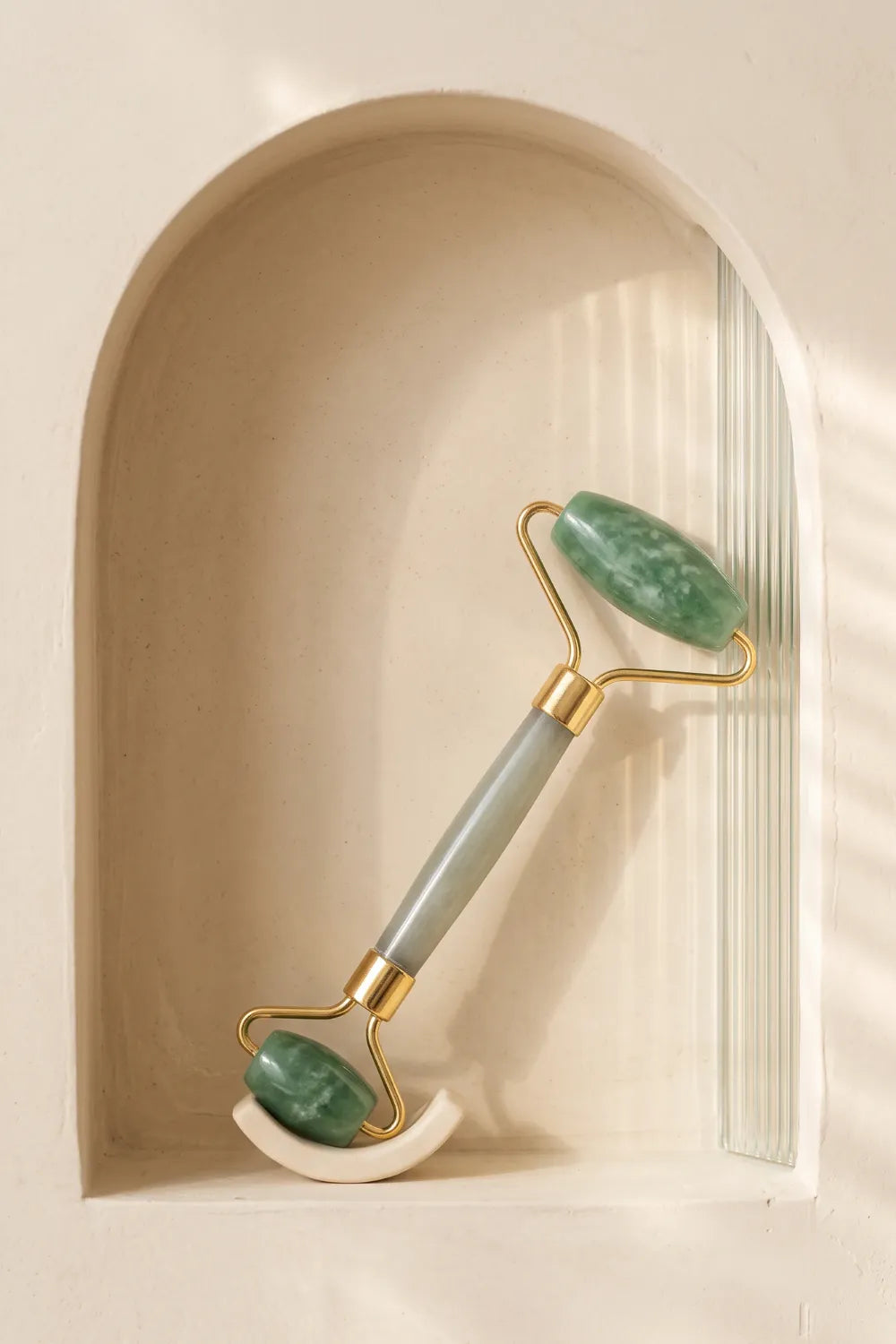 Rodillo de jade expuesto en un nicho decorativo de estilo minimalista con luz suave.